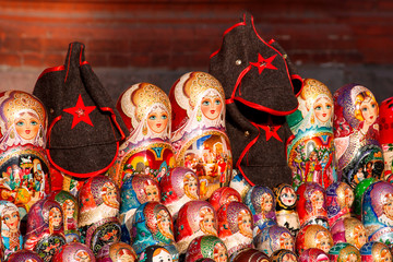 Russian traditional nested dolls - matryoshka. Soviet military headdress of the 20th XX centure. Dolls and huts are on sale as souvenirs for tourists.