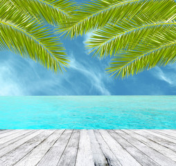 Beautiful tropical beach with wooden floor and palm leaves