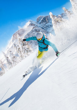 Skier skiing downhill in high mountains