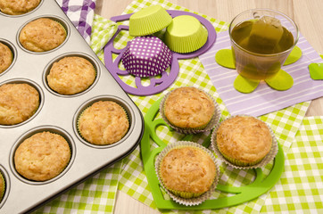 Muffins in a tray and on colorful napkin. Cup a tea and muffins on heart shape holder.