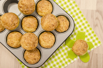 Muffins in a tray on green napkin. Twelve muffins in a tin tray.