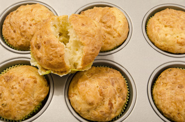 Close up on muffins in a tray and a sliced opened muffin.Muffins in a tin tray.