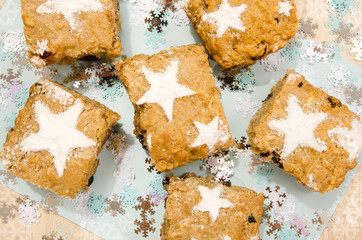 Christmas apple cake with icing sugar stars. Pieces of cake on blue background with snowflakes decoration.