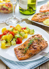 Spice grilled salmon with mango-avocado salsa on a white plate
