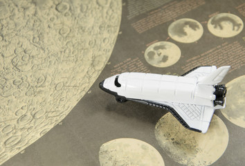 toy spaceplane with moon map background