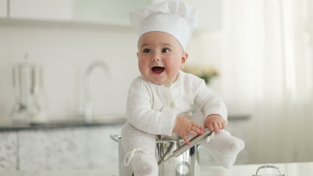 Little cook sitting in pot with ladle in hand