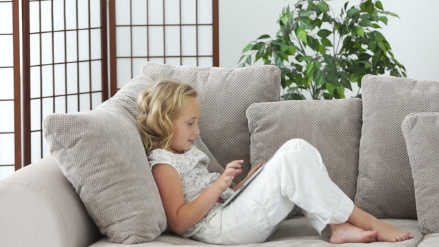 Girl with tablet pc on sofa