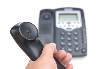 man holding a black telephone receiver on a white background