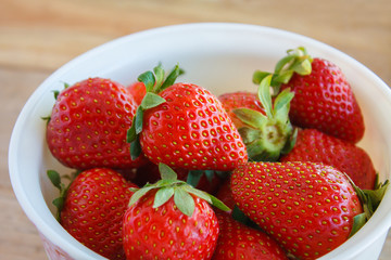 Ripe red strawberries on wooden table