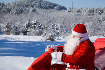 Obraz premium Santa with sack in winter forest