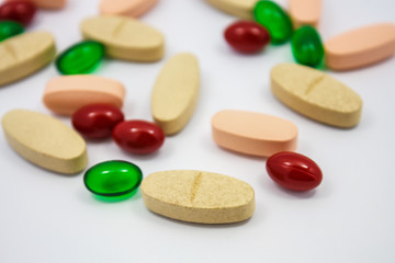 Colored pills, tablets and capsules on a white background