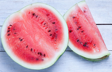 Fresh ripe sliced watermelon on a wooden table.
top view