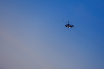 silhouette of helicopter in azure sky