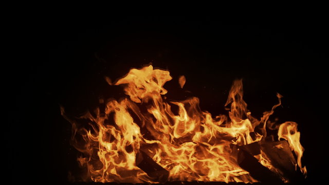 Real big shot fire in slow motion with particles on black background, perfect for film, digital composition, seamlesly looped.