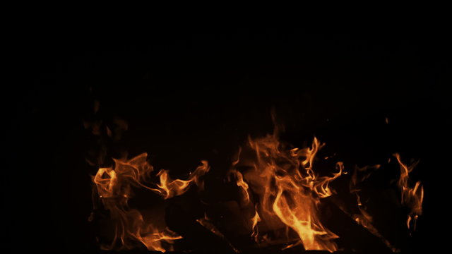Real medium shot fire in slow motion with particles on black background, perfect for digital composition