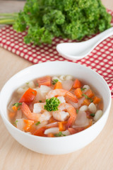 Macaroni with shrimp soup on white bowl.