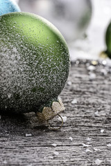 Weihnachtskugeln auf Holz mit Schnee als Detail
