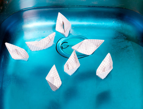many small paper boat floating in a steel shell 