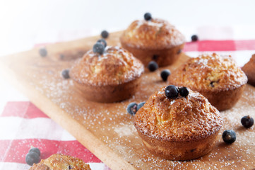 Freshly baked muffins sprinkles with sugar and black currant ber