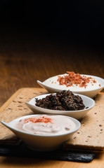 Three different sauces served on a wooden table 