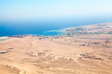 Aerial view at the sandy desert terrain and Red sea coast with resorts in Hurghada, Egypt