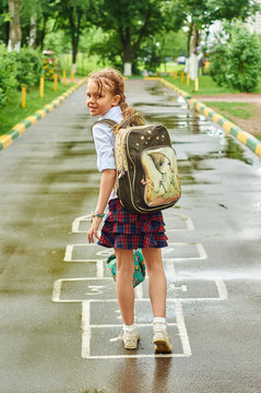 Nice schoolgirl playing hopscotch