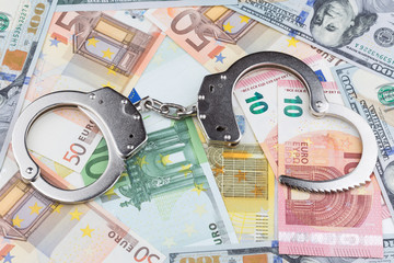 Handschellen auf dem Hintergrund von Banknoten