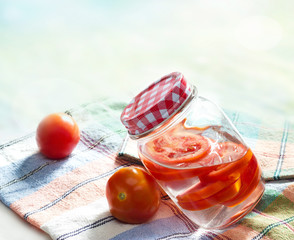 Detox diet water of fresh tomato in the jar on fabric pastel color
