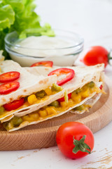 Quesadilla with sour cream, salad and tomatoes