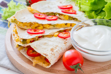 Quesadilla with sour cream, salad and tomatoes
