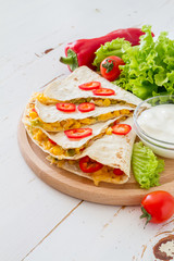 Quesadilla with sour cream, salad and tomatoes