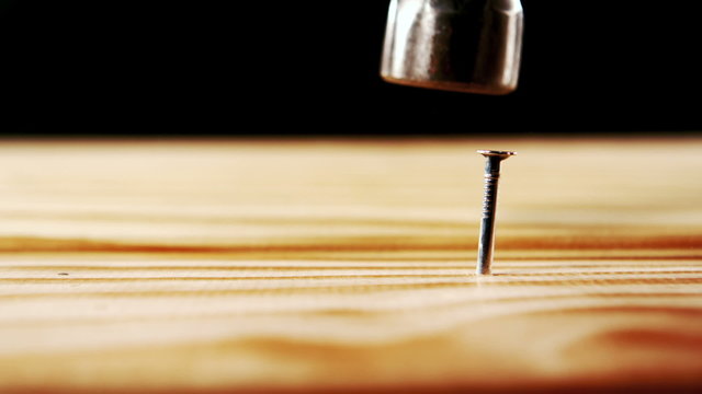Hammer hammering nail into wood