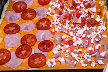 pizza with tomatoes, chicken, corn, crab sticks and cheese