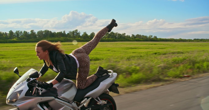 Talented girl performing motorbike trick on road