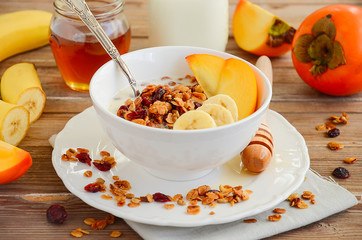 Homemade granola with nuts and dried cranberries on the rustic wooden table