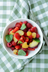 berries salad with peach in bowl
