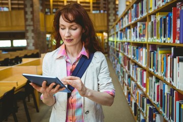 Mature student in the library using tablet