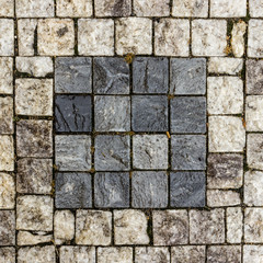 Pavement of granite blocks dark square on a light background