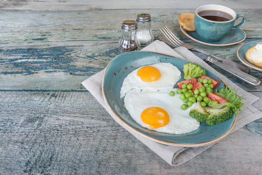 Fried eggs, vegetables and cup of coffee