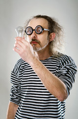 the aged man in a sailor looking at the lightbulb isolated on the white background 