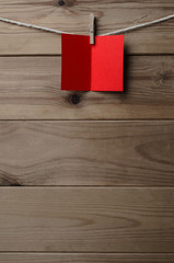 Red Blank Greetings Card Pegged to String on Wood Background