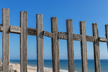 Obraz premium Antique wooden fence on the background of the sea. Blue sky.
