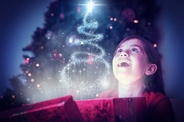 Composite image of little girl opening a magical christmas gift