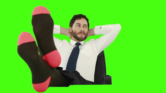 Businessman relaxing in his chair with legs up and with no shoes