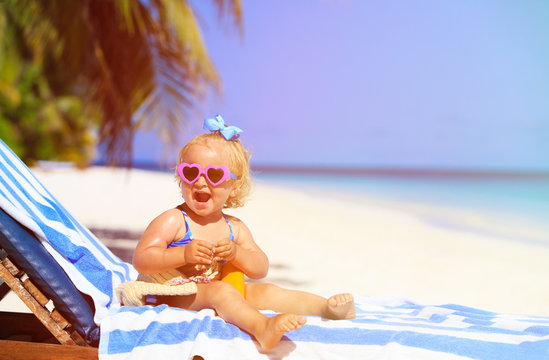 cute little girl with sunblock cream on beach