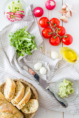 Summer sandwich and ingredients on white wood background