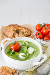 Arugula and tomatoes puree soup in white bowl