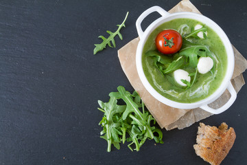 Arugula and tomatoes puree soup in white bowl