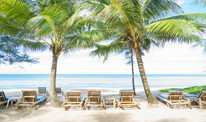 Fototapeta na wymiar Beach chairs and palms on the beach