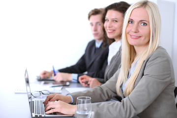 Obraz premium A group of business people at a meeting on the background of office. Focus on a beautiful blonde